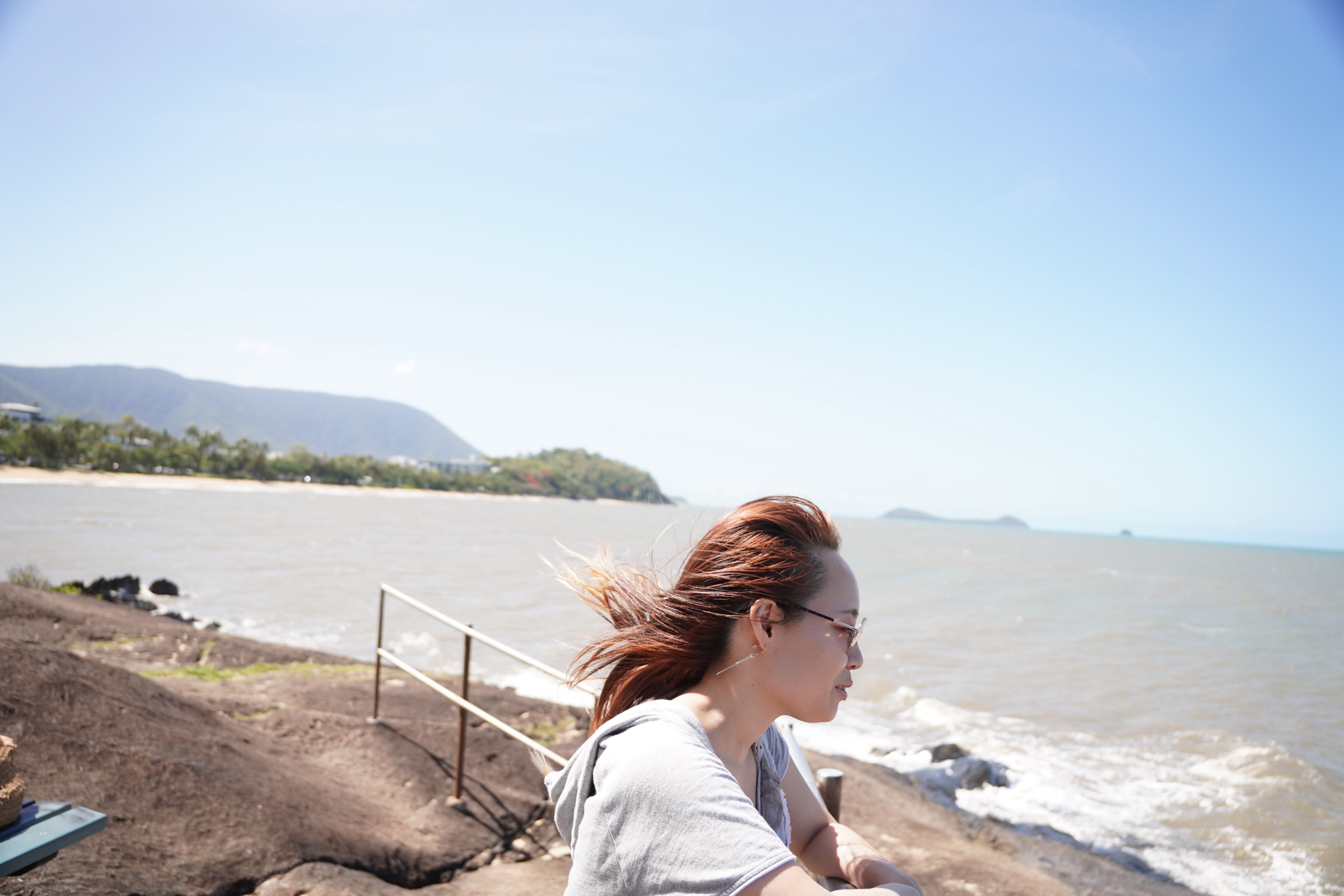 持田清香。ケアンズの海辺で、風になびく髪